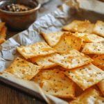 golden Gruyère crackers on rustic parchment
