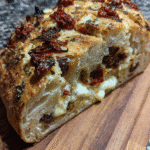 Mediterranean-Stuffed Sourdough Loaf on serving board